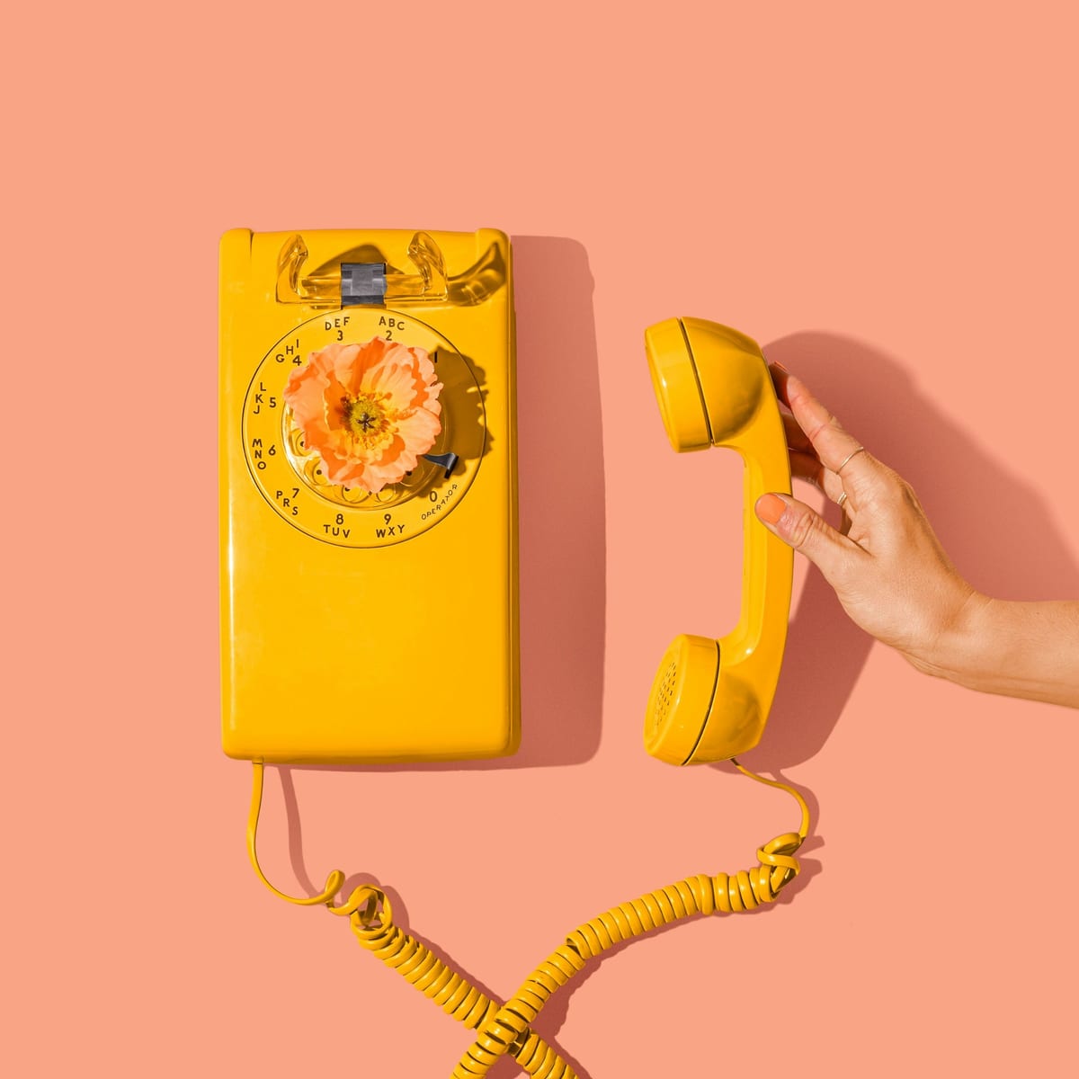 A cheerful yellow telephone receiver with a flower